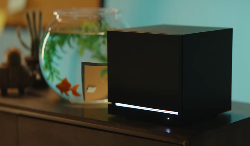 A picture of the steam machine next to a fish bowl with a goldfish in it.